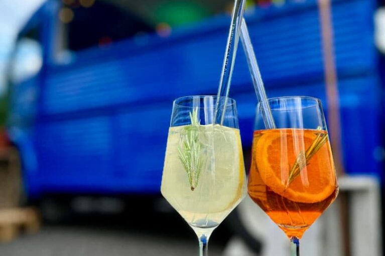 Sommerliche Drinks vor einem blauen Getränke-Foodtruck