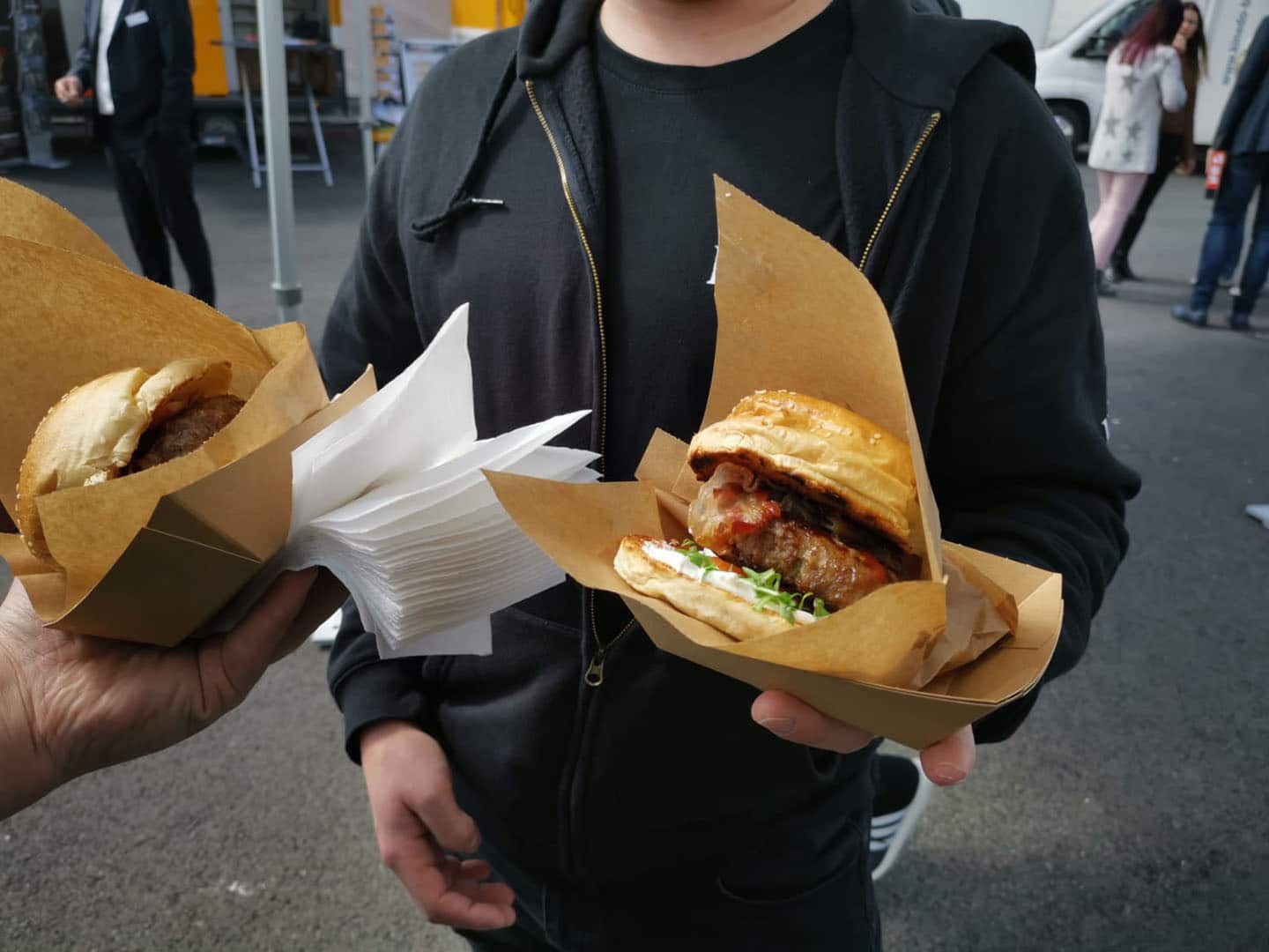 Gäste halten Ihre frischen Burger mit Bacon