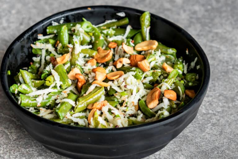 Eine schwarze Schale, die mit Gemüse und Nüssen als Bowl befüllt ist