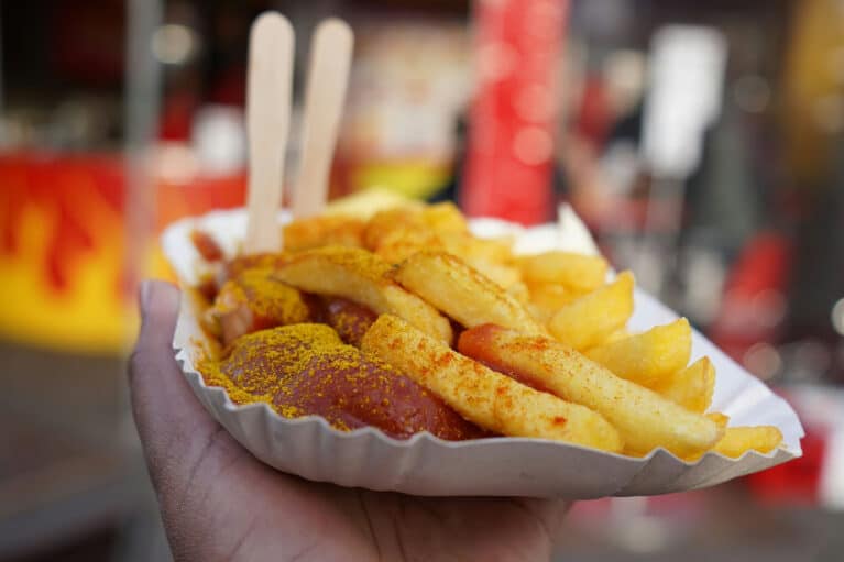 Currywurst und Pommes in einer Pappschale