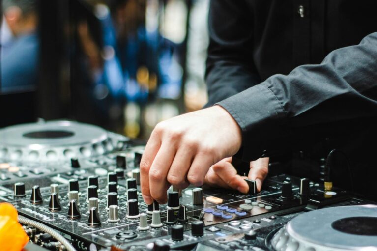 Ein DJ, der an seinem Mischpult steht und für Musik sorgt